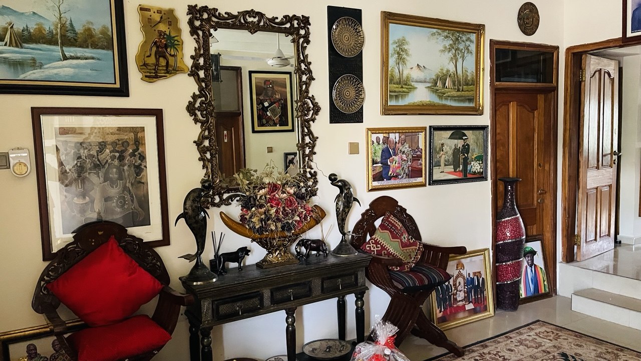 Heritage hall interior with carved mirror and framed portraits in Accra by FreeCoat