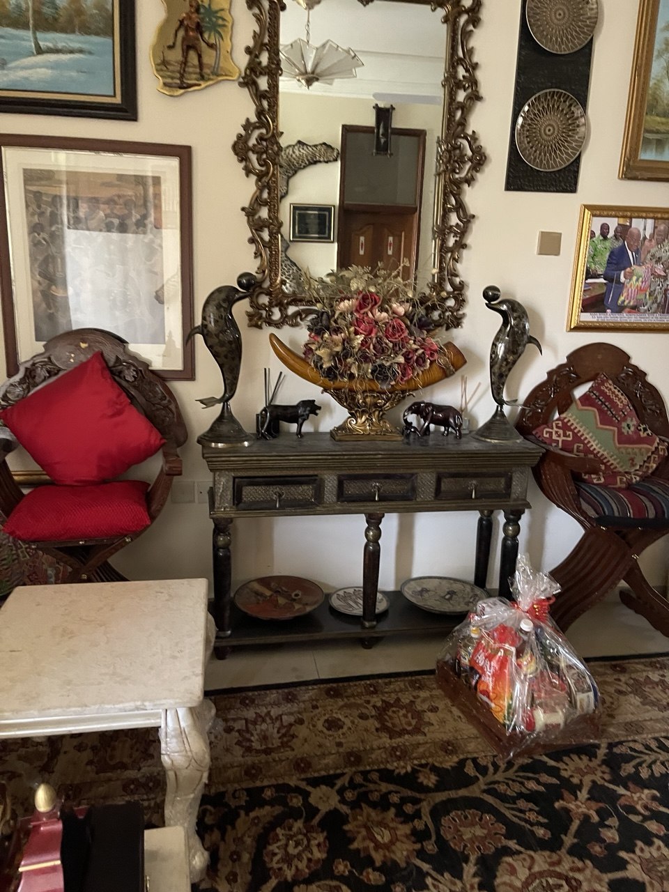 Heritage hall with framed photos and carved furniture by FreeCoat Decor Accra