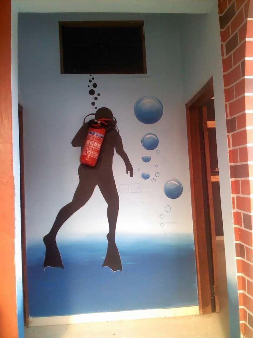 Hand-painted scuba diver wall mural with fire extinguisher at entrance Accra